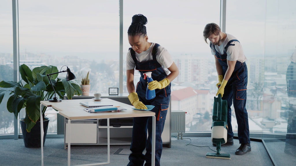 Gestionnaire et technicien de nettoyage vérifiant la qualité du travail dans des bureaux